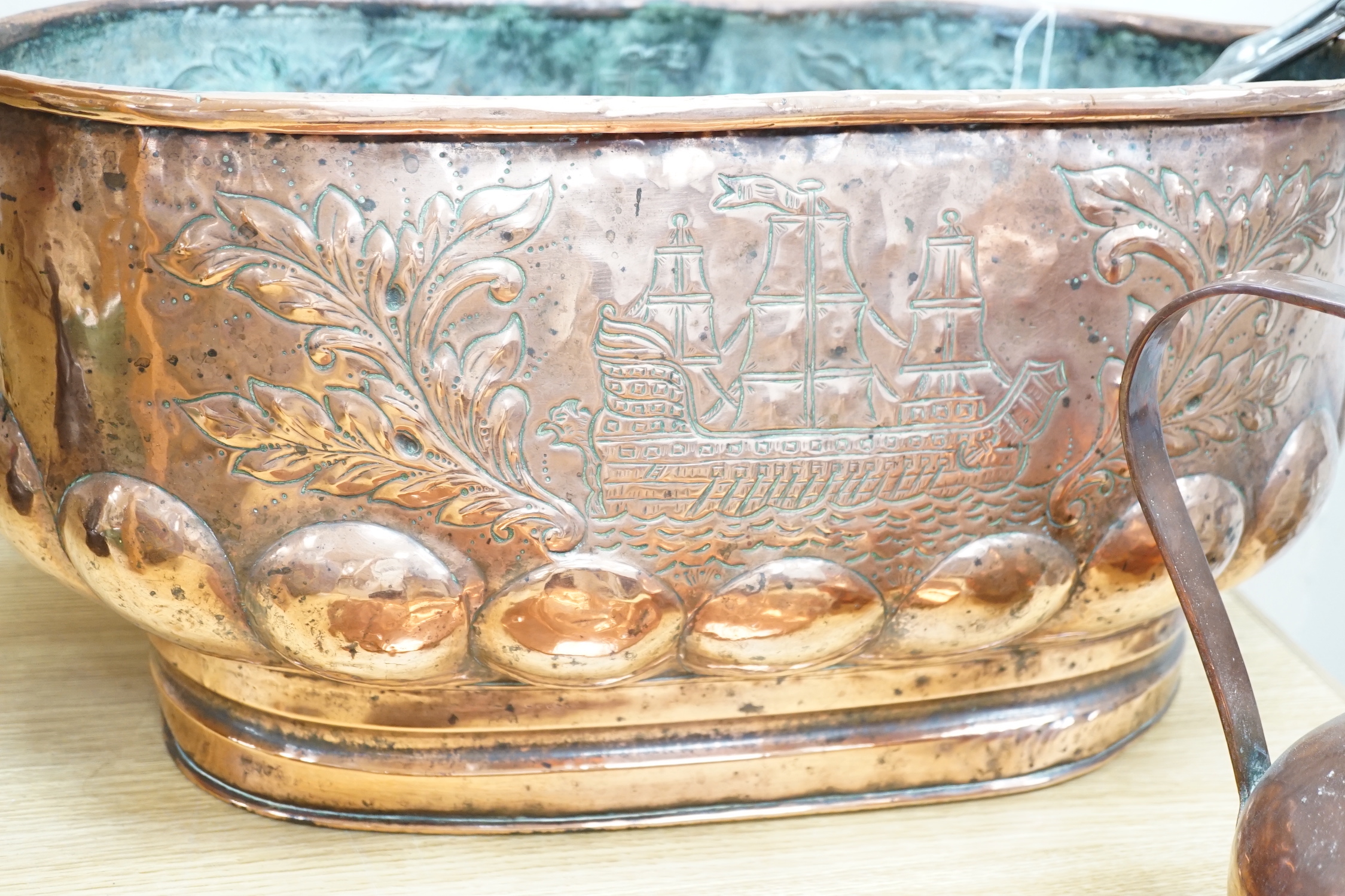 An 18th century Dutch beaten copper planter of elongated form with lion mask handles, beaten ship decoration and heavy gadrooning, 62cm long (Provenance Bonhams Chester 31/10/03). A large 19th century copper jug, baluste